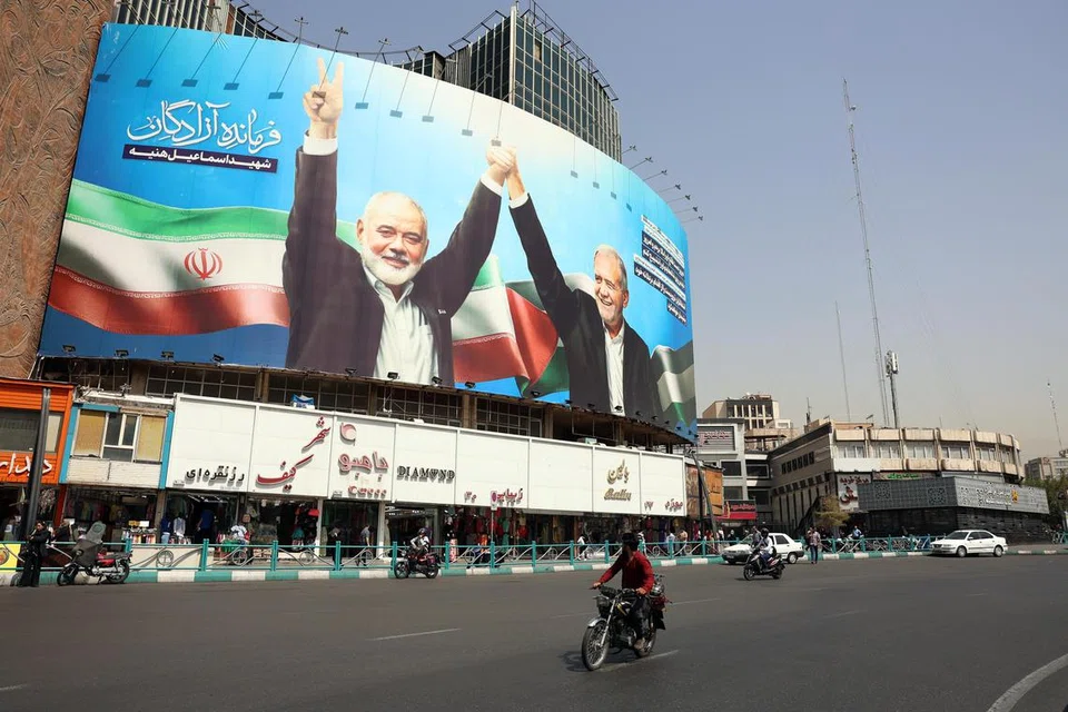 Papan iklan memaparkan Presiden Iran Encik Masoud Pezeshkian (kanan) dan pemimpin Hamas Encik Ismail Haniyeh yang baru meninggal dunia, di Dataran Valiasr di Tehwran, Iran, pada 5 Ogos 2024 sedang pemimpin Iran Ayatollah Khamenei berikrar untuk menjatuhkan ‘hukuman keras’ terhadap Israel sebagai membalas dendam atas pembunuhan Encik Haniyeh di Teheran pada 31 Julai 2024.