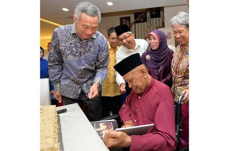 SAMBUTAN MERIAH: (Dari kiri) Encik Lee, Dr Mohamad Maliki, Dr Yaacob, isteri Encik Othman, Cik Lina Abdullah; dan isteri Perdana Menteri, Cik Ho Ching, sama-sama meraikan hari ulang tahun Encik Othman Wok (duduki) yang ke-91 tahun di rumahnya semalam. Encik Lee telah menghadiahkan album yang menampilkan foto diri Encik Othman dari zaman dulu hingga sekarang, kepadanya. - Foto M.O. SALLEH