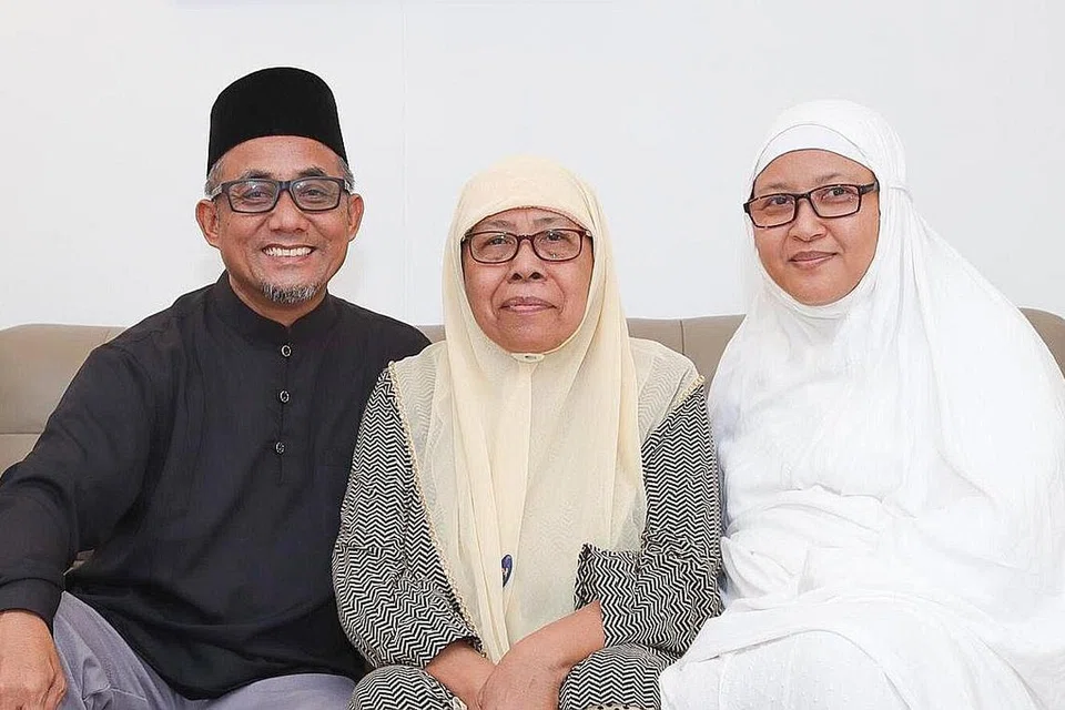HADIAH UNTUK IBU: Cik Nurulazmi (kanan) mengetepikan $100,000 daripada Akaun Biasa (OA) CPF beliau untuk dimasukkan ke RA CPF ibunya Cik Jamilah (tengah) selepas bapanya meninggal dunia pada 2012. Bersama mereka ialah suami Cik Nurulazmi, Encik Sumri Rafe. - Foto ihsan NURULAZMI MANAN