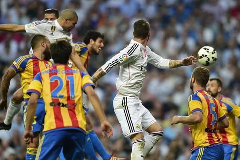 GOL: Pemain pertahanan Portugal Real Madrid, Pepe (jersi putih, kiri) menanduk masuk bola dalam perlawanan menentang Valencia kelmarin. - Foto AFP