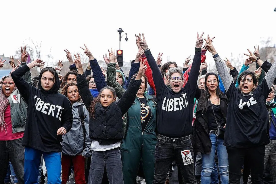 BERI SOKONGAN: Penunjuk perasaan di Paris pada 8 Mac menyokong wanita muda yang menari tanpa tudung di dalam video yang tular di media sosial. - Foto EPA-EFE