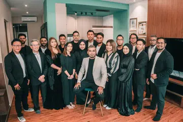 MAJU JAYA: Encik Muhammad Syahiran Rohajat (tengah, duduk) bersama pasukannya di Singapura yang turut membantu beliau meluaskan perniagaan di Malaysia. 