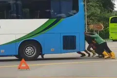 SEMANGAT KEMASYARAKATAN: Beberapa pekerja asing ini meninggalkan apa yang mereka sedang lakukan untuk bantu tolak bas rosak ini agar ia tidak menghalang lalu lintas.