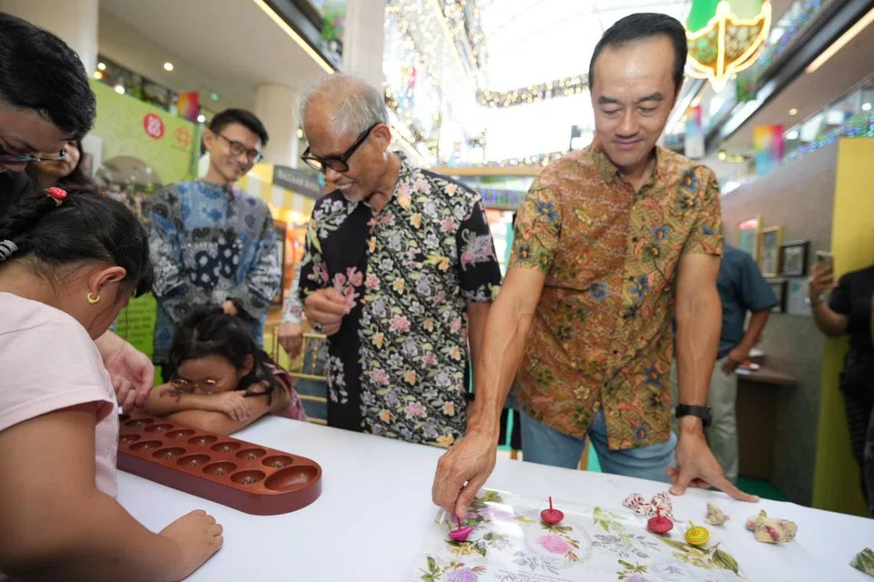 Anggota Parlimen (AP) GRC Tampines, (dari kanan) Dr Koh Poh Koon, Encik Masagos Zulkifli Masagos Mohamad dan Encik Baey Yam Keng, berinteraksi bersama kanak-kanak kecil dan bermain permainan tradisional seperti gasing dan congkak.