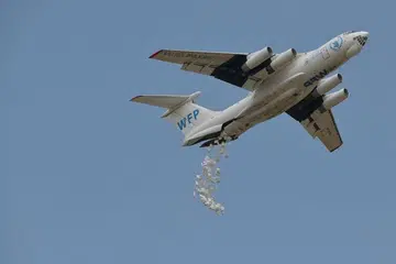 KEADAAN GETIR: Pesawat buatan Russia, Ilyushin, yang dipajak oleh Program Makanan Sedunia (WFP) melepaskan bungkusan makanan dari udara di sebuah kampung di daerah Ayod, Selatan Sudan, pada 6 Februari lalu. 