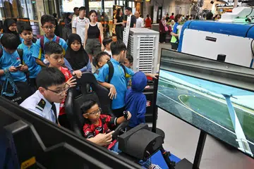 Seorang pengunjung muda ke reruai Aeroaviation di Raikan Ilmu @Heartlands cuba menerbangkan pesawat menggunakan mesin simulator. 