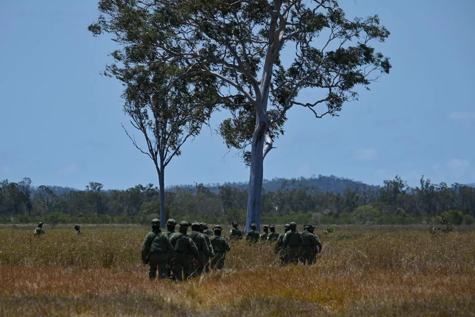Anggota Angkatan Bersenjata Singapura (SAF) bergerak merentasi kawasan lapang sambil menuju ke Zon Pengambilan, di mana anggota Angkatan Udara Republik Singapura (RSAF) bakal dibawa ke lokasi seterusnya melalui helikopter ‘Chinook’. 