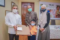 TERIMA HADIAH: Pesakit ginjal, Muhammad Ghazy Qays, bersama ibunya, Cik Nur Amallina Nasir, menerima hadiah komputer riba daripada presiden MKAC, Encik Ameerali Abdeali, dan Mufti Dr Nazirudin Mohd Nasir, semalam. - Foto BM oleh NUR DIYANA TAHA