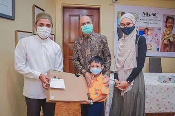 TERIMA HADIAH: Pesakit ginjal, Muhammad Ghazy Qays, bersama ibunya, Cik Nur Amallina Nasir, menerima hadiah komputer riba daripada presiden MKAC, Encik Ameerali Abdeali, dan Mufti Dr Nazirudin Mohd Nasir, semalam. - Foto BM oleh NUR DIYANA TAHA