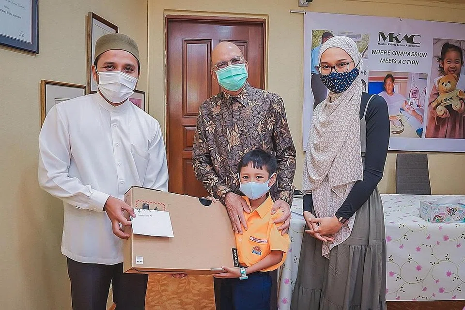 TERIMA HADIAH: Pesakit ginjal, Muhammad Ghazy Qays, bersama ibunya, Cik Nur Amallina Nasir, menerima hadiah komputer riba daripada presiden MKAC, Encik Ameerali Abdeali, dan Mufti Dr Nazirudin Mohd Nasir, semalam. - Foto BM oleh NUR DIYANA TAHA