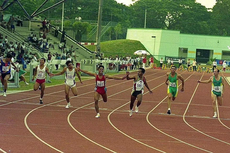 KEMENANGAN MANIS: Hosni (nombor 607) meraikan kemenangannya ke atas Mardi Lestari (nombor 595) yang tidak lama dulu merupakan antara pelumba terpantas di Asia semasa bersaing di Terbuka Atletik Singapura pada 1994. - Foto fail