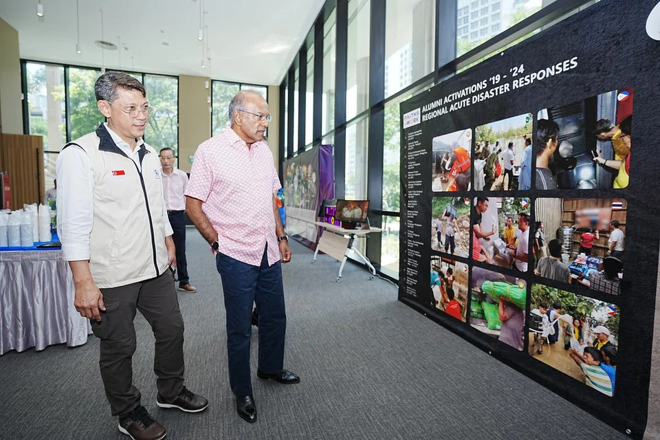 Penasihat khas bagi Humanity Matters, Encik Hassan Ahmad (kiri), berkongsi dengan Menteri Ehwal Dalam Negeri merangkap Undang-Undang, Encik K. Shanmugam, tentang misi kemanusiaan badan itu dan usaha yang pernah dilakukan menerusi pameran yang diadakan di majlis pelancaran Asean Care pada 19 Ogos di Pusat Punggol Soka, dan turut dihadiri wakil negara Asean yang lain. 