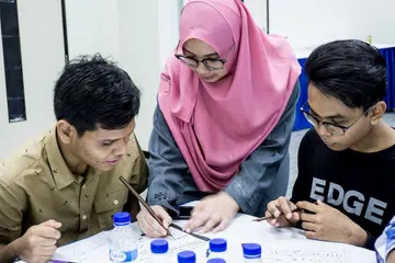 BIMBING BELIA: Beberapa peserta di bengkel tulisan khat di Masjid En-Naeem. Seorang tenaga pengajar muda di bengkel itu ialah Cik Siti Nur Amirah Mohammad Raimi, yang pakar dalam empat jenis tulisan khat. - Foto BH oleh NUR DIYANA TAHA