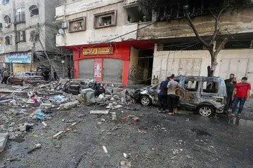 HADAPI SERANGAN: Rakyat Palestin memeriksa kenderaan yang turut hangus selepas jet pejuang Israel membedil sebuah rumah di Kota Gaza, Palestin, semalam. - Foto REUTERS 