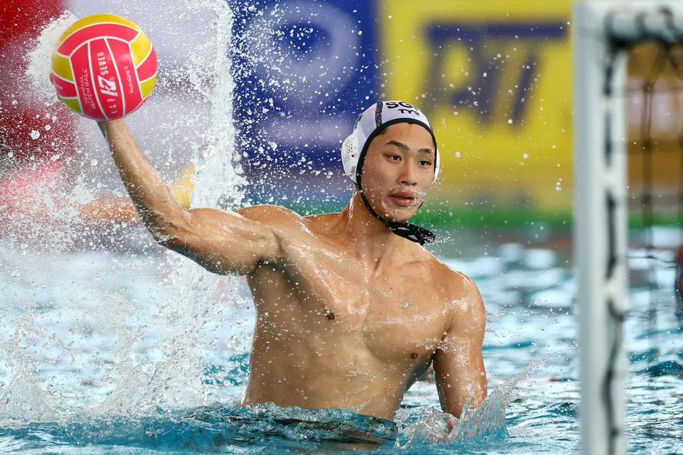 Seorang pemain polo air Singapura membuat satu percubaan gol.