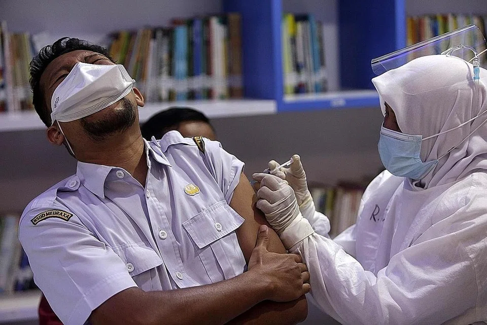 UTAMAKAN PEKERJA KESIHATAN: Seorang pekerja kesihatan sedang disuntik dengan vaksin Covid-19 semasa program vaksinasi di Indonesia pada 9 Februari lalu. Data terkini merekodkan separuh daripada mereka yang meninggal dunia akibat Covid-19 adalah golongan orang berusia 60 tahun ke atas. - Foto EPA-EFE