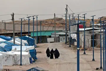 Wanita berjalan di Kem Roj yang menempatkan anggota keluarga individu yang disyaki menyertai kumpulan ISIS di timur laut Syria pada 5 Oktober 2026. Kem yang dikawal ketat pasukan Kurdi itu menempatkan lebih 2,200 orang daripada 729 keluarga dan lebih 50 kewarganegaraan, ketika proses menyerahkan pentadbirannya kepada pemerintah Syria dijangka mengambil masa.