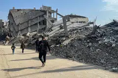 Penduduk Palestin berjalan melewati runtuhan rumah yang musnah di tengah-tengah gencatan senjata antara Israel dan Hamas di Khan Younis, selatan Jaluran Gaza, pada 6 Mac 2025.
