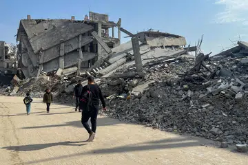 Penduduk Palestin berjalan melewati runtuhan rumah yang musnah di tengah-tengah gencatan senjata antara Israel dan Hamas di Khan Younis, selatan Jaluran Gaza, pada 6 Mac 2025.