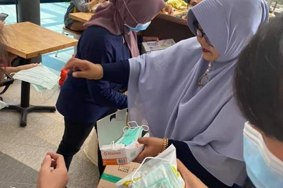GOTONG-ROYONG: Beberapa warga Indonesia bergotong-royong membahagi-bahagikan pelitup dan snek kepada orang ramai di kawasan Payar Lebar pada Ahad (9 Februari).