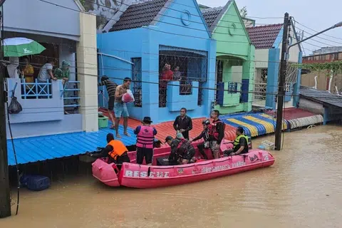 Anggota pasukan penyelamat mengagih bekalan kepada penduduk yang terperangkap di kawasan banjir di daerah Hat Yai, wilayah Songkhla, pada 24 November.