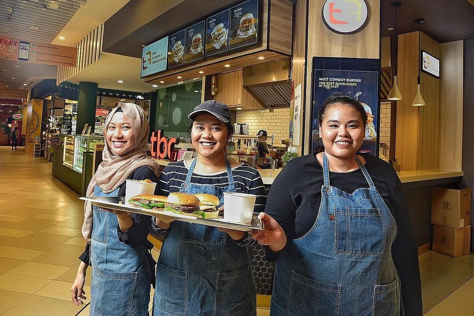 TIDAK LAGI MUSTAHIL: Cik Syahirah (tengah) yang mendapat sokongan adiknya Cik Syafiqah (kiri) dan pengurus pemasarannya, Cik Diyana Amin (kanan), berkata respons kepada kedainya di OTH ini sememangnya di luar jangkaan. - Foto BM oleh DESMOND WEE