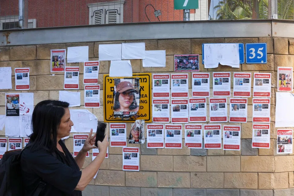TUNTUT PEMBEBASAN: Seorang wanita memetik gambar dengan telefon bimbitnya imej para tebusan Israel yang diculik kumpulan Hamas dalam serangan pada 7 Oktober.