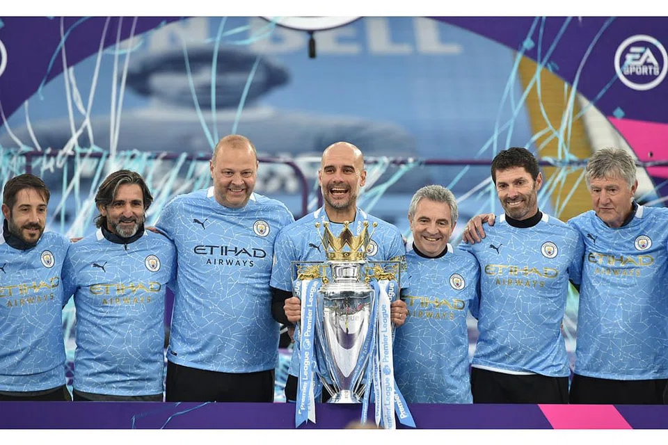 PENGURUS TERBAIK: Pengurus Manchester City, Pep Guardiola (tengah) bersama kakitangannya meraikan kejayaan merangkul trofi Liga Perdana. - Foto EPA-EFE