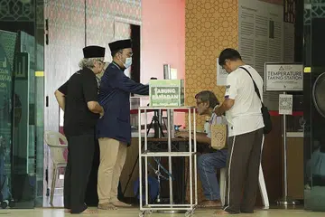 RINDU KE MASJID: Jemaah di Masjid An-Nahdhah di Bishan menjalani pemeriksaan suhu badan dan mengisi borang pengisytiharan perjalanan dan kesihatan sebelum dibolehkan menggunakan ruang solat kecil yang disediakan untuk mereka menunaikan solat zuhur. - Foto BH oleh AZMI ATHNI