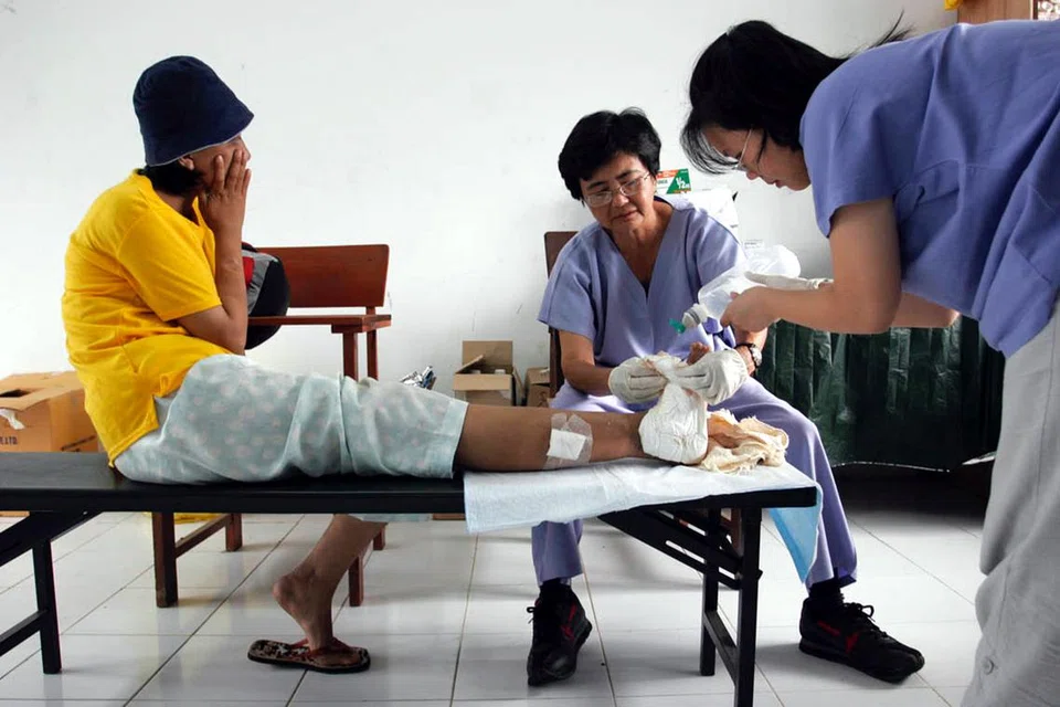 Dua jururawat membalut mangsa tsunami di hospital sementara di Banda Aceh.