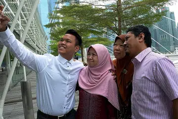 DETIK GEMBIRA: Fazlie Mohamad Ramdan (kiri) bergambar bersama (dua dari kiri) ibunya, Cik Zaiton Mohamad, neneknya, Cik Rohani Abdul Rahman, dan ayahnya, Encik Mohamad Ramdan Sofan. - Foto ZAINAL YAHYA