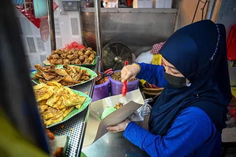 SIBUK: Gerai nasi lemak Pak Mandor Nasi Lemak dirus bersama anak pemilik, Cik Jumianti setiap hari.
