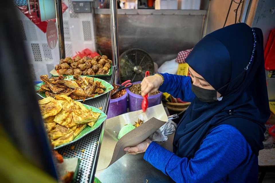 SIBUK: Gerai nasi lemak Pak Mandor Nasi Lemak dirus bersama anak pemilik, Cik Jumianti setiap hari.