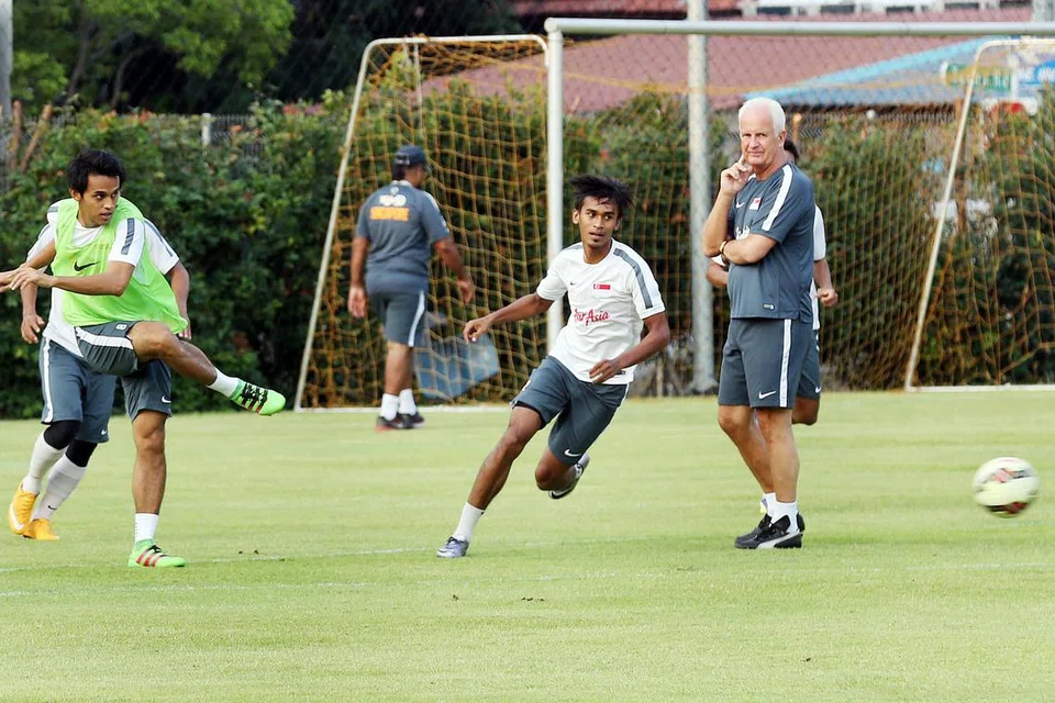 GIAT BERLATIH: Jurulatih nasional Bernd Stange (kanan) menyelia latihan pasukan Singapura kelmarin menjelang perlawanan persahabatan dengan Myanmar malam ini sebagai persiapan menghadapi Afghanistan dalam perlawanan kelayakan Piala Dunia 2018 pada 29 Mac. - Foto THE STRAITS TIMES