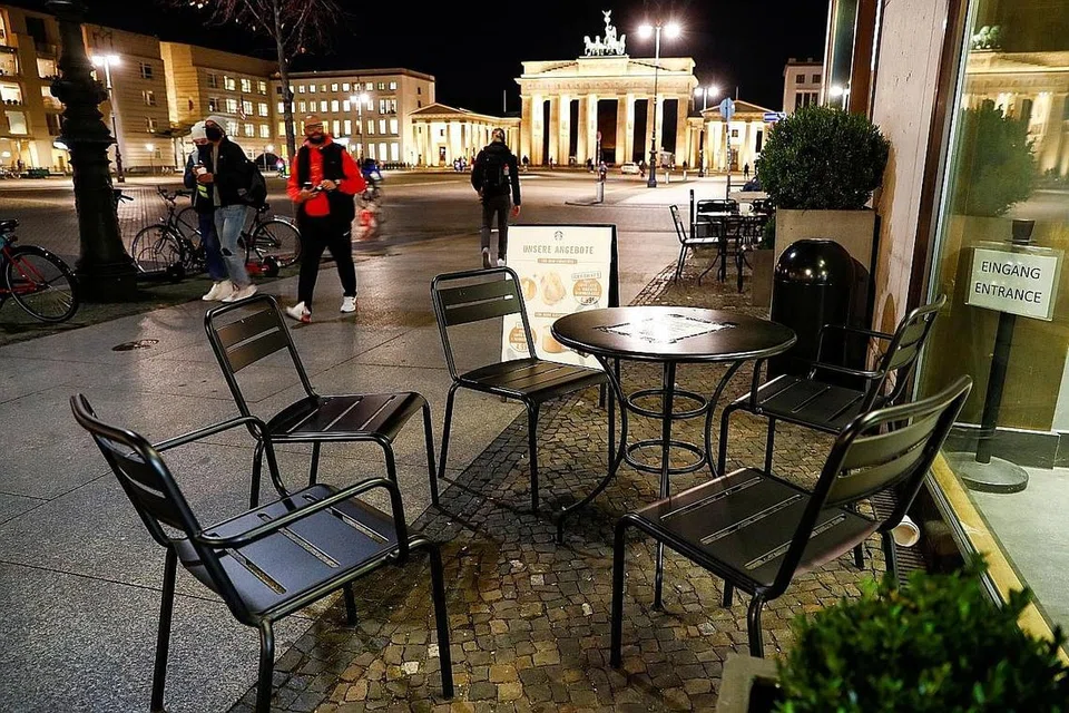 SUNYI SEPI: Orang ramai berjalan lalu di kafe yang tiada pengunjung di Brandenburg Gate, Berlin, Jerman, pada Rabu lalu sedang penularan koronavirus terus melanda negara itu. - Foto REUTERS