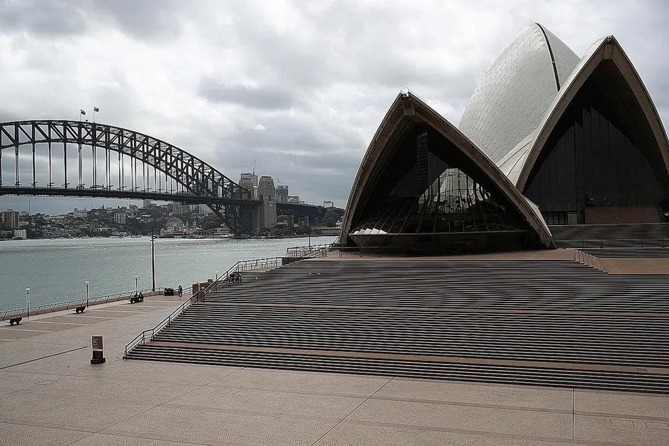 HANYA SEDIKIT YANG BERKUNJUNG: Kumpulan kecil pengunjung boleh dilihat duduk di tangga Sydney Opera House di Australia pada 26 Mac, sejurus selepas New South Wales mengumumkan perintah untuk menutup perniagaan bagi perkhidmatan tidak wajar dan bertindak untuk memperuntuk hukuman lebih berat bagi penduduknya mengamalkan pengasingan diri. Mengikut undang-undang yang baru diperkenalkan di wilayah itu - yang mengandungi jumlah penduduk paling tinggi di Australia -- mereka yang keluar rumah tanpa sebab yang diterima boleh dikenakan saman dalam jumlah besar atau dipenjarakan. - Foto REUTERS