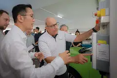 KEMUDAHAN DISEDIAKAN: Encik S Iswaran (kanan) meninjau stesen mengecas kenderaan elektrik (EV) ChargEco di tempat letak kereta Telok Blangah Drive. Terdapat lagi dua stesen mengecas di lokasi itu. - Foto ST