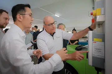KEMUDAHAN DISEDIAKAN: Encik S Iswaran (kanan) meninjau stesen mengecas kenderaan elektrik (EV) ChargEco di tempat letak kereta Telok Blangah Drive. Terdapat lagi dua stesen mengecas di lokasi itu. - Foto ST