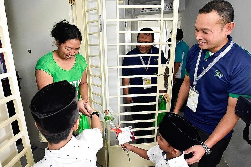 SEBAR RAHMAH: Timbalan Ketua Eksekutif Muis, Encik Fahmi Aliman (kanan), bersama kakitangan Muis dan keluarga mereka serta sukarelawan Roses of Peace mengagihkan bubur dan bunga mawar kepada penduduk di Serangoon North sempena Ramadan lalu. - Foto fail