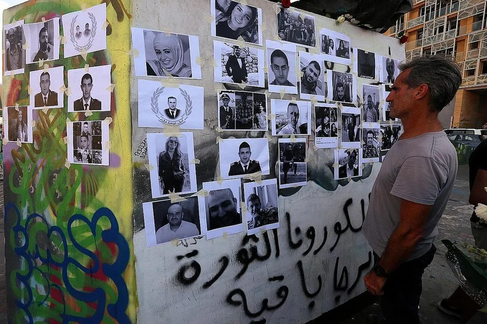 WAJAH-WAJAH MANGSA: Lelaki di Beirut sedang melihat senarai mangsa yang terkoraban dalam insiden letupan baru-baru ini. - Foto REUTERS