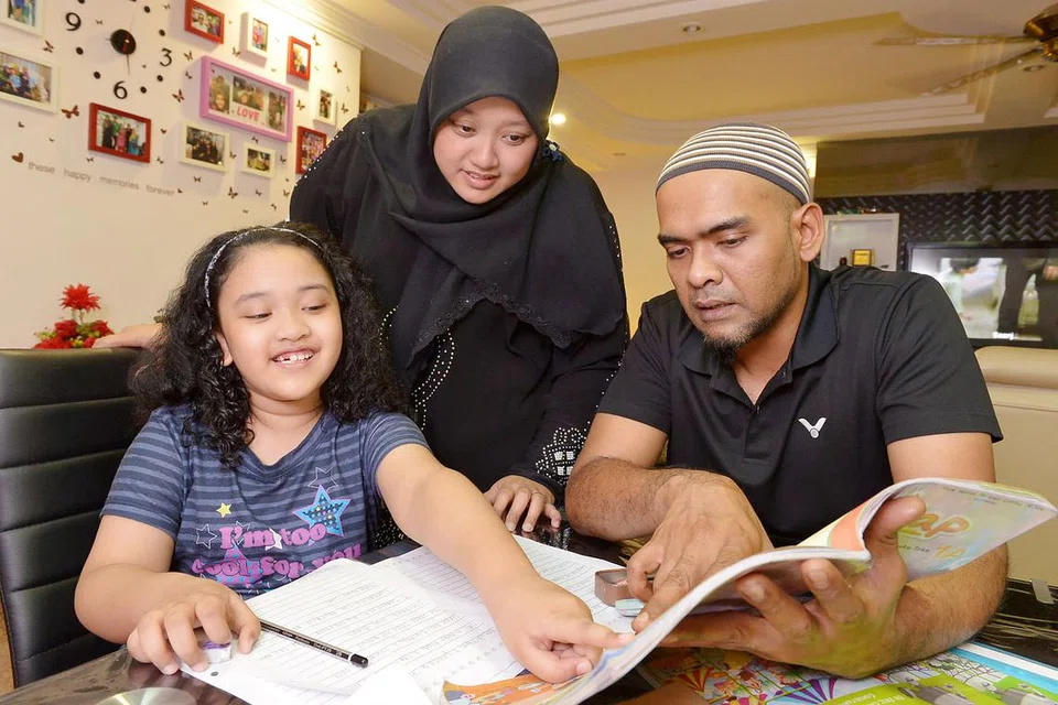 DITERIMA BAIK: Encik Mohamad Nazer dan Cik Juliyani berharap sistem PSLE baru dapat membantu pembangunan pelajar secara menyeluruh, seperti kemajuan anak tunggal mereka Nur Arisha Naurah. - Foto TUKIMAN WARJI