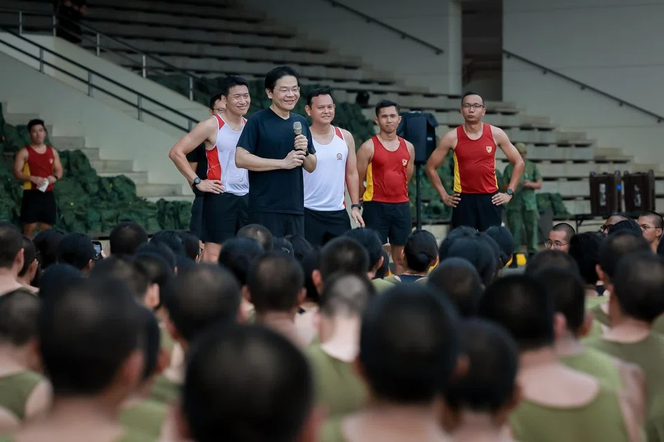 Perdana Menteri, Encik Lawrence Wong (empat dari kanan), berucap di hadapan sekitar 420 rekrut selepas berlari bersama mereka ketika mengunjungi Pulau Tekong. Beliau diiringi Menteri Negara Kanan (Pertahanan merangkap Tenaga Manusia), Encik Zaqy Mohamad (tiga dari kanan). 