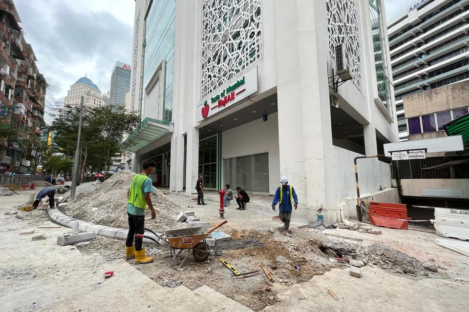 Pekerja menjalankan kerja pemasangan batu kerb di kawasan kejadian lubang benam di Jalan Masjid India, Kuala Lumpur. 
