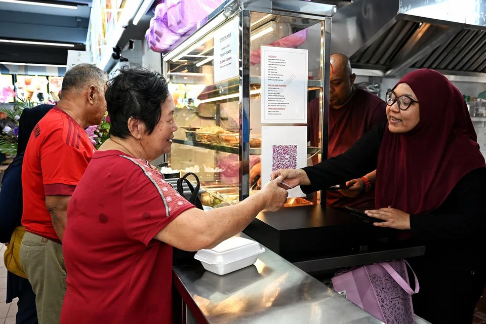 Cik Nurulhuda Basir dan Encik Mohamad Nazreen Saini melayan pelanggan yang berkunjung ke Nurul Delights di Blok 318, Jurong East Street 31.