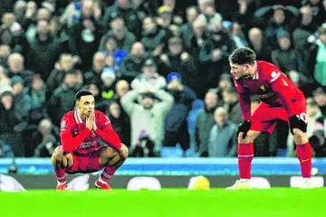Dua pemain Liverpool, Trent Alexander-Arnold (kiri) dan Alexis Mac Allister, kelihatan kecewa selepas Everton menyumbatkan gol penyamaan pada minit-minit terakhir perlawanan.