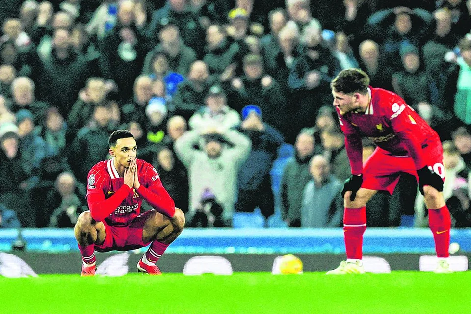 Dua pemain Liverpool, Trent Alexander-Arnold (kiri) dan Alexis Mac Allister, kelihatan kecewa selepas Everton menyumbatkan gol penyamaan pada minit-minit terakhir perlawanan.
