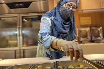 MENINGKAT SECARA BERTAHAP: Sharifah Noor Aishah berkata perniagaannya, Restoran Jinshang Yipin Halal Hotpot & BBQ Buffet di pusat beli-belah Eastpoint Mall (atas), meningkat secara bertahap hingga 30 peratus sejak pelanggan dibenar ambil makanan bufet sendiri. - Foto BH oleh FARID HAMZAH