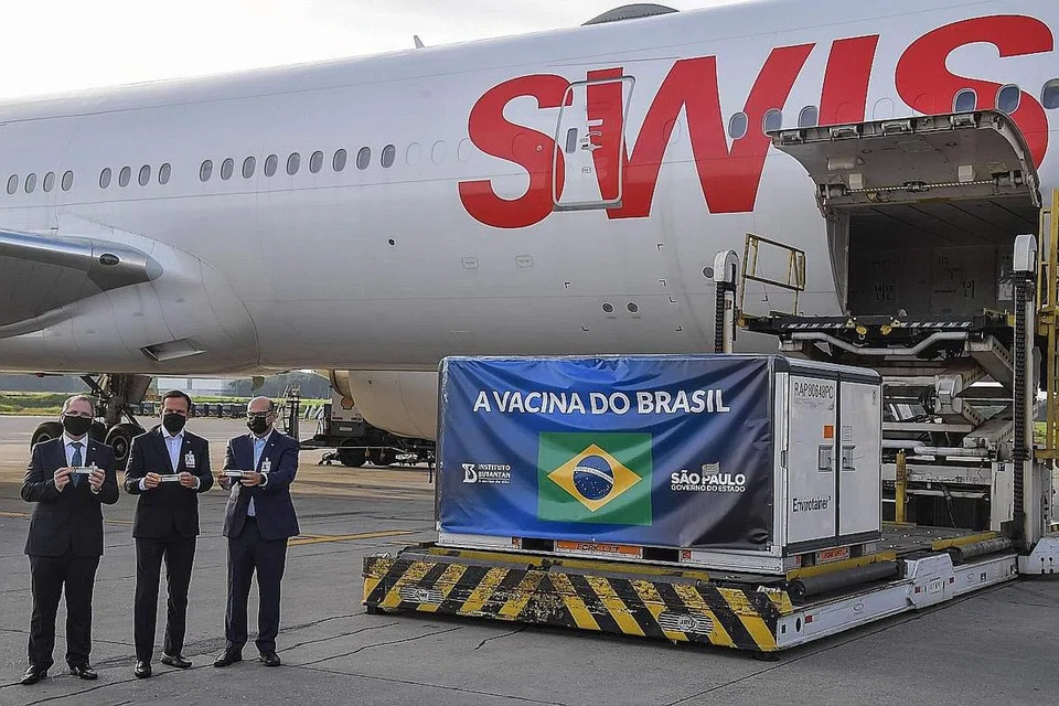 PENAWAR ATASI COVID-19: (Dari kiri) Setiausaha Kesihatan Sao Paulo, Dr. Jean Gorinchteyn; Gabenor Sao Paulo, Encik Joao Doria dan Pengarah Institut Butantan, Encik Dimas Covas bergambar bersebelahan kontena mengandungi vaksin CoronaVac selepas dipunggah keluar dari pesawat kargo yang sampai dari China di Lapangan Terbang Antarabangsa Guarulhos, dekat Sao Paulo, Brazil, pada 3 Disember lalu. - Foto AFP