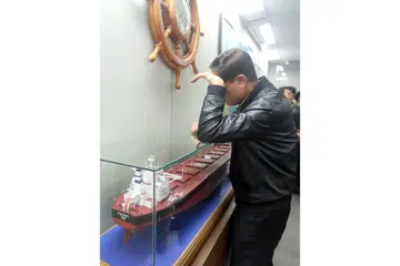 PENCARIAN DITERUSKAN: Ahli keluarga melihat model kapal 'Stella Daisy' sementara menunggu maklumat mengenai nasib anak kapal kargo itu, di ibu pejabat syarikat perkapalan Polaris Shipping di Busan, Korea Selatan. - Foto AFP