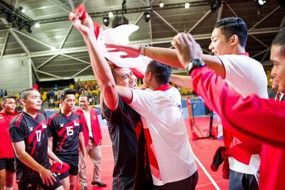 CATAT SEJARAH: Kapten pasukan sepak takraw Farhan (memegang bendera) meraikan pingat perak yang dimenangi semalam. - Foto SPORT SINGAPORE